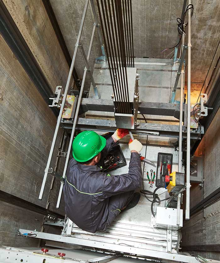 A worker repairs an elevator
