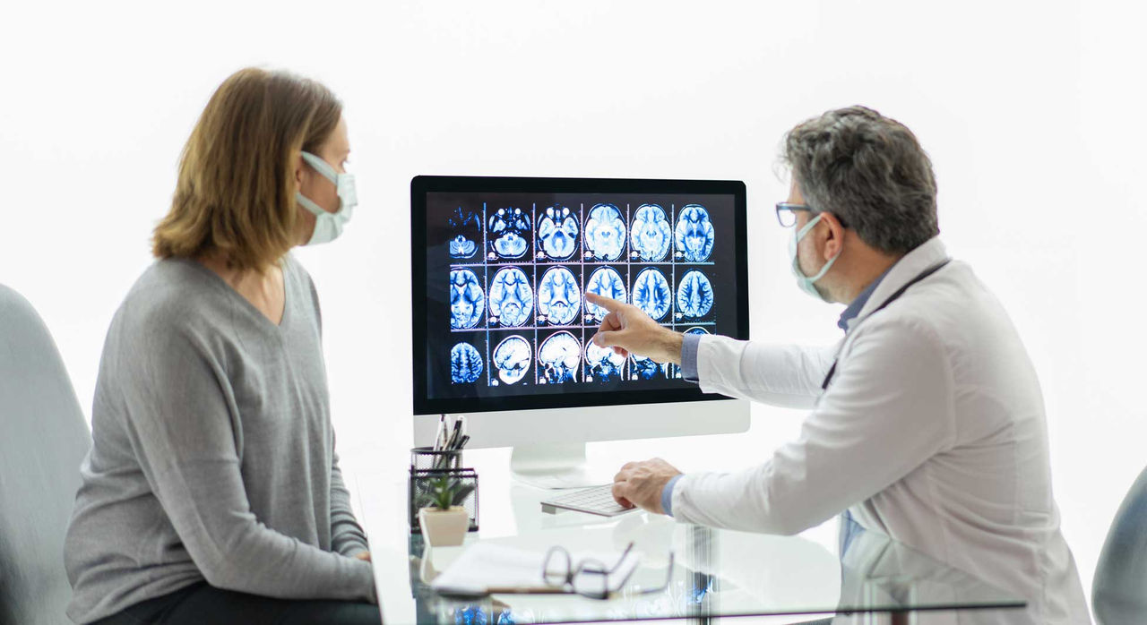 A doctor and patient review brain scans.