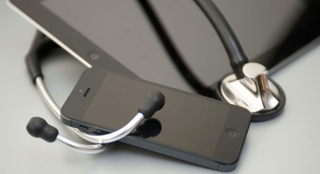 Stethoscope on top of a tablet and smartphone