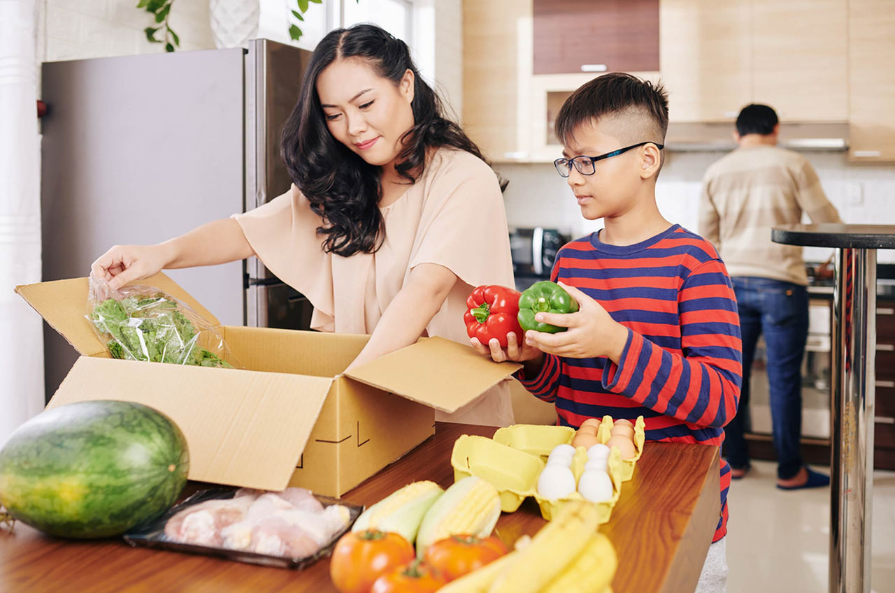 A mother and son unpack fresh groceries