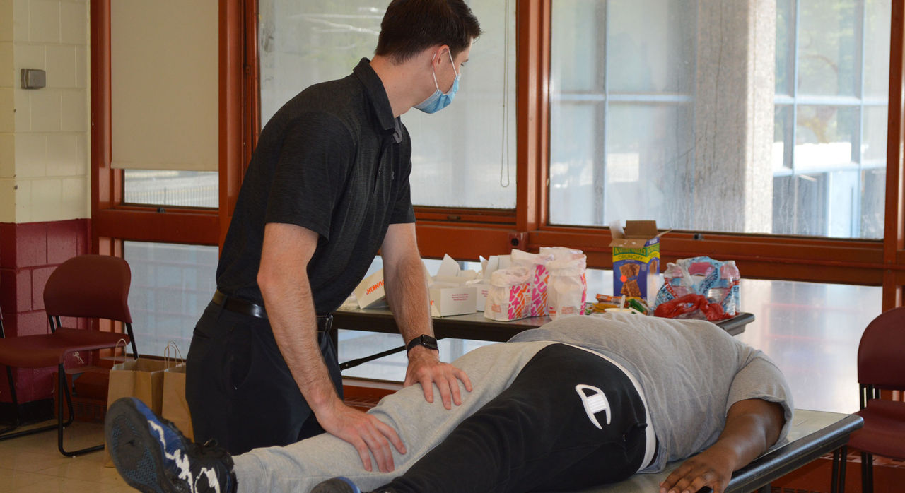 Sports medicine therapist exams patient on table