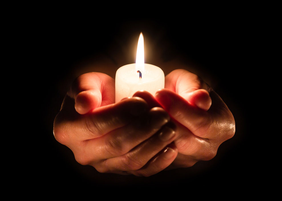 Lighting a memorial candle is one way to honor a deceased love one during the holidays.