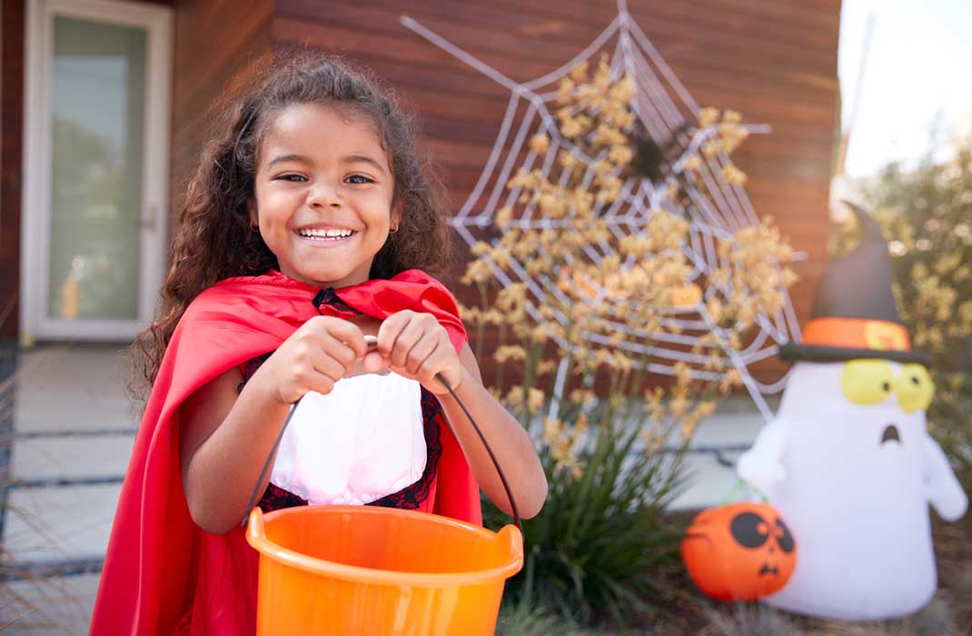 A costumed little girl with a Halloween pail.