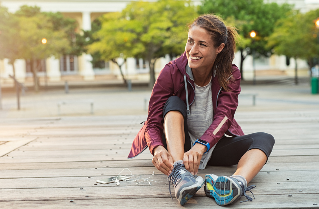 Female marathon runner tying shoes. 