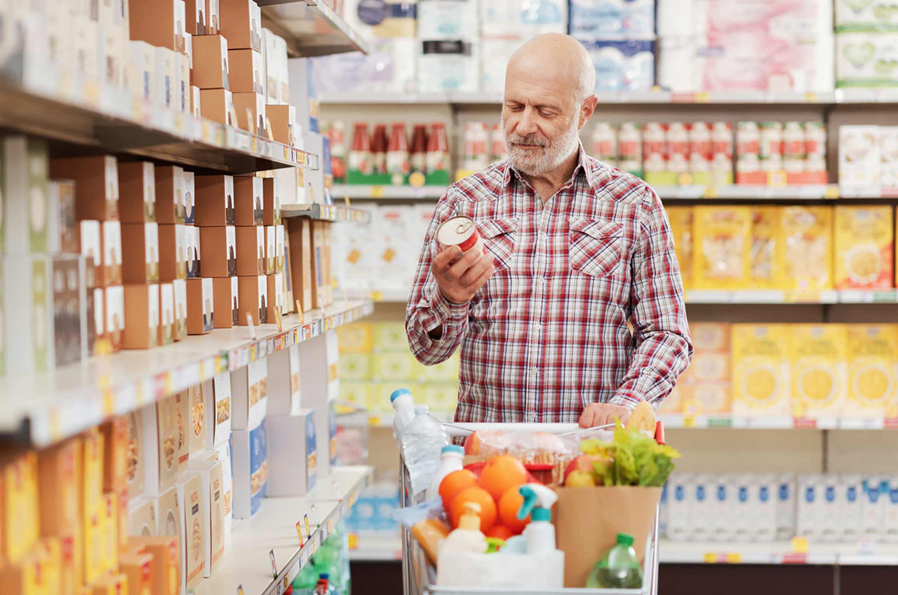 A man checks the content of a can of soup at the grocery store