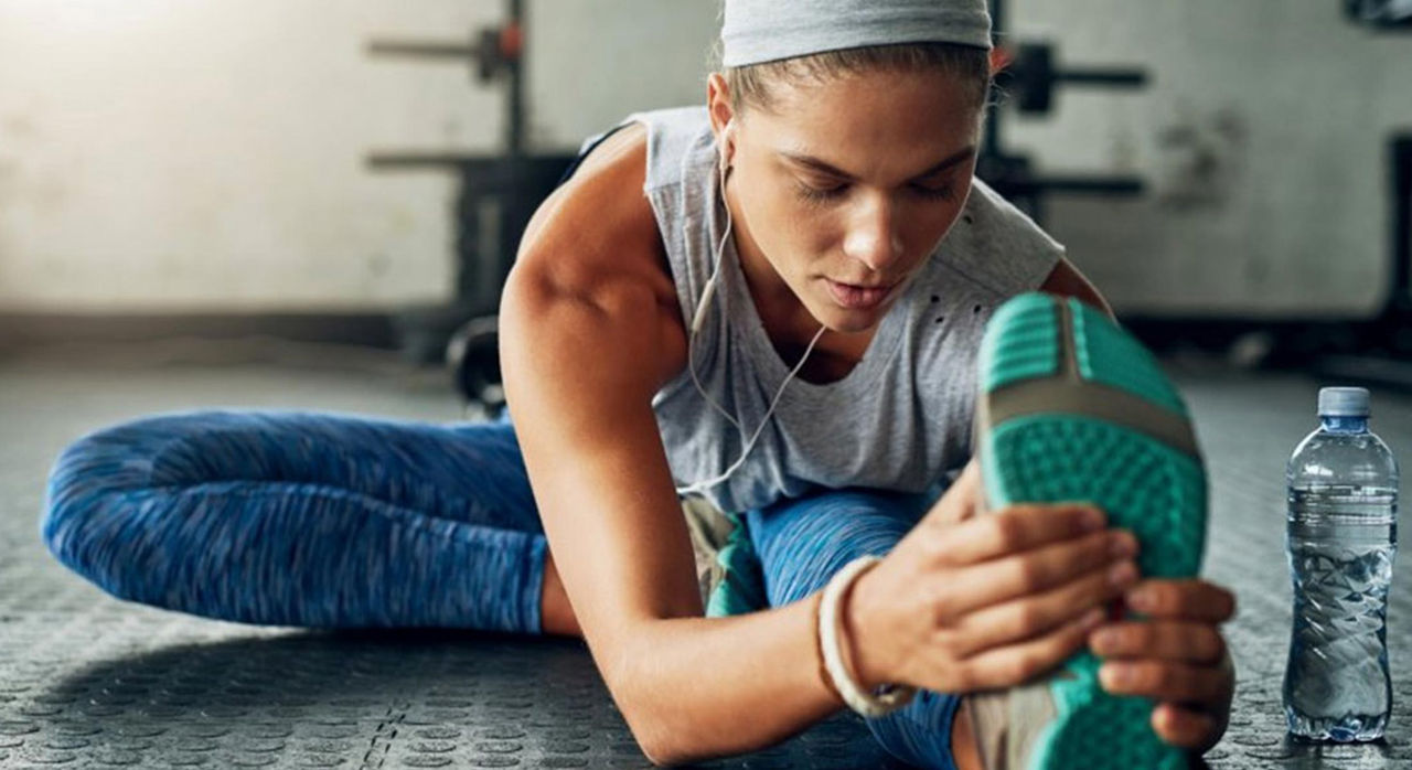 woman on floor stretching her leg