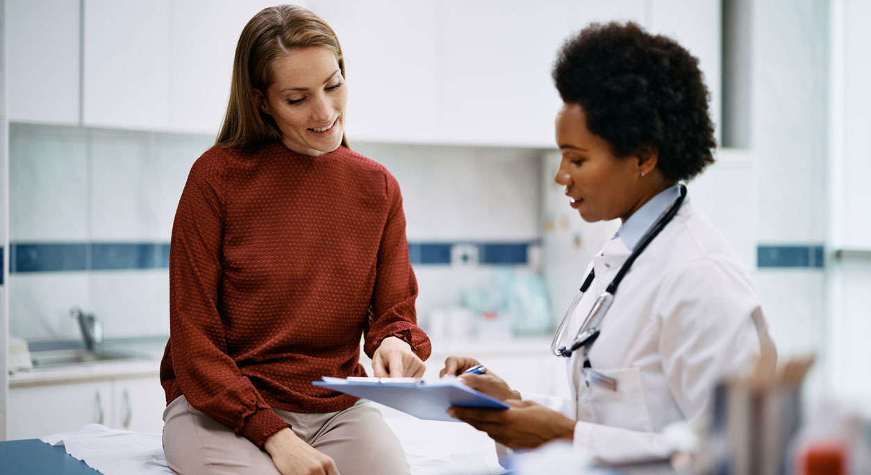 A female doctor reviews medical data with her patient.