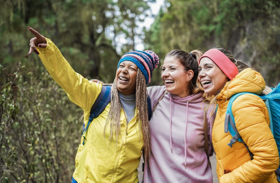 A group of friends hiking together in the woods, exercising to prevent heart attacks.