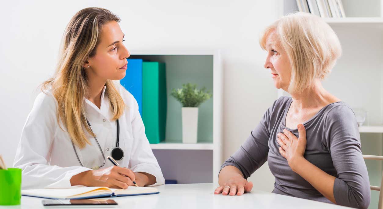 A woman gets her heart examined by a doctor using a stethoscope