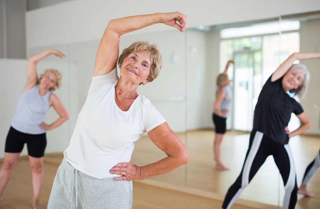 Three senior women in an exercise class.