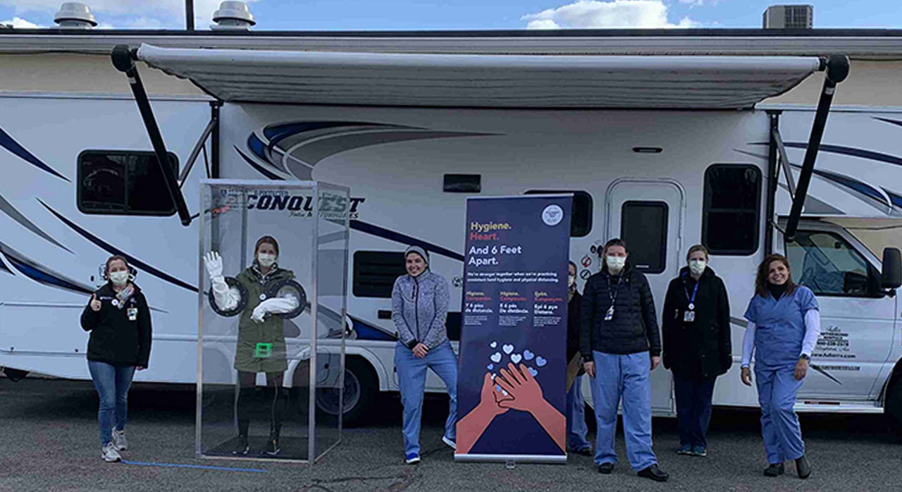 workers in front of COVID-19 testing van