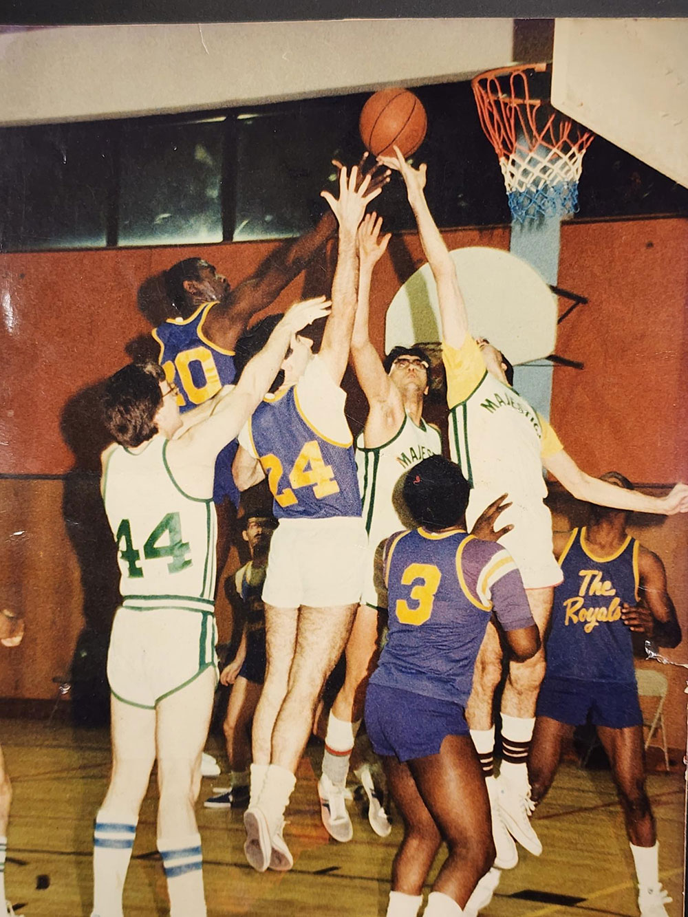 An early 80's photo of basketball players at the hoop, trying to make a goal.