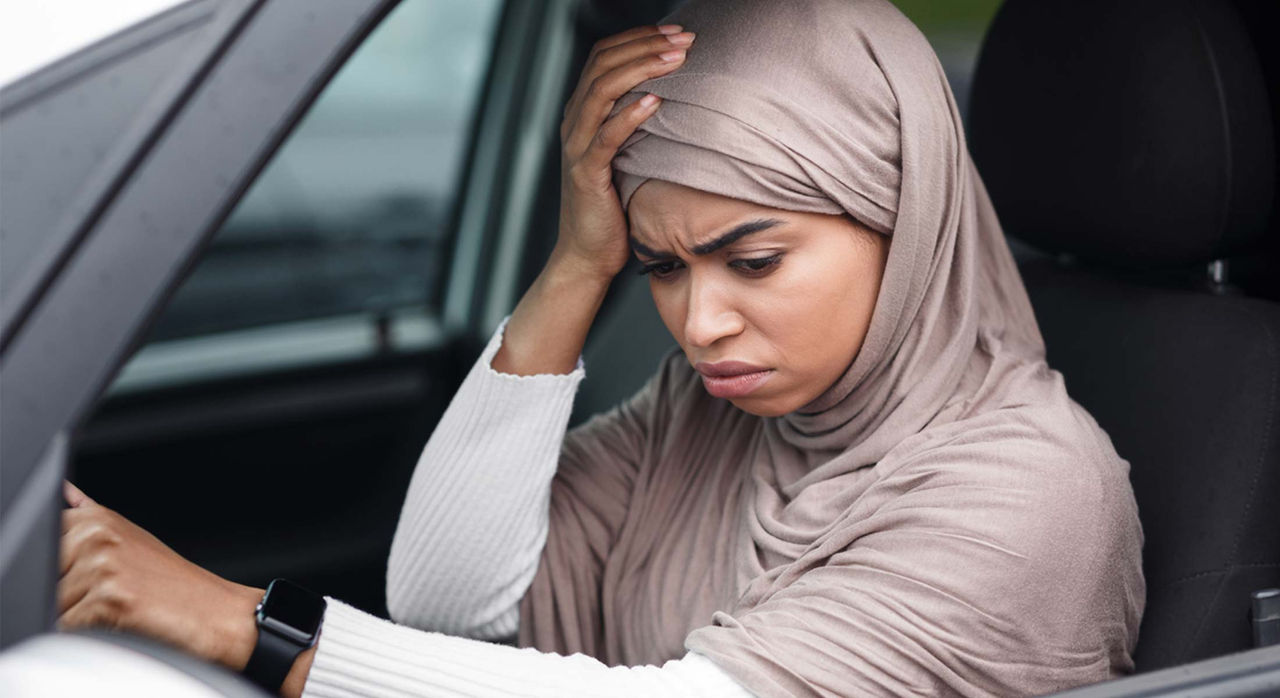 Woman touching her head with her right hand due to a migraine