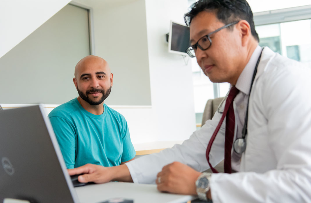 Doctor reviews most common cancers in men with patient. 