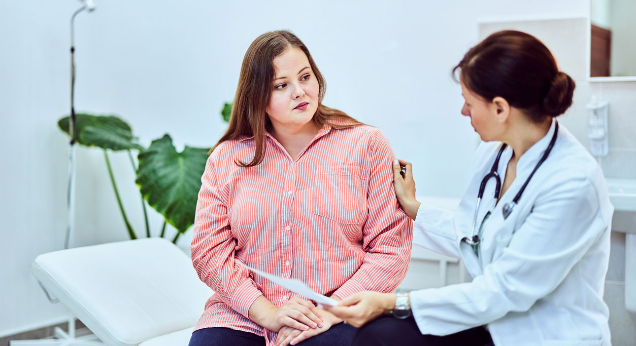 An overweight woman talks with her doctor.
