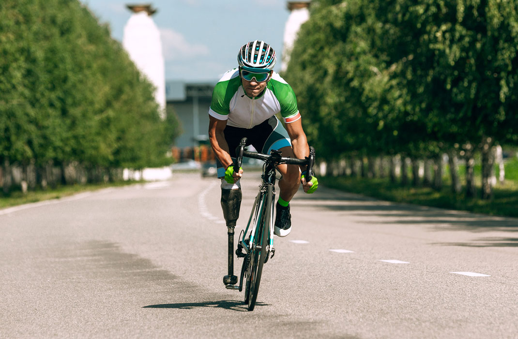 An athlete with a prosthetic leg rides his two-wheeled leg cycle.