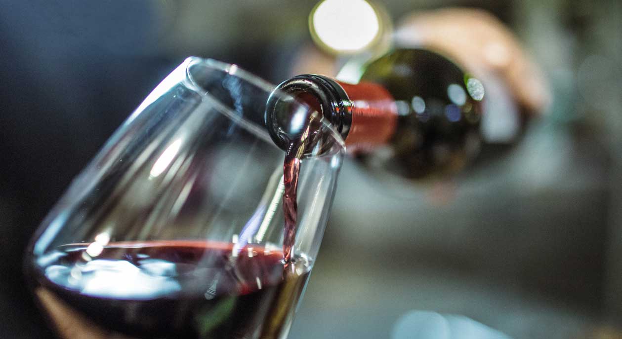 Red wine being poured into a glass.