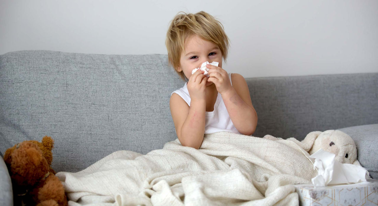 A sick child blows their nose