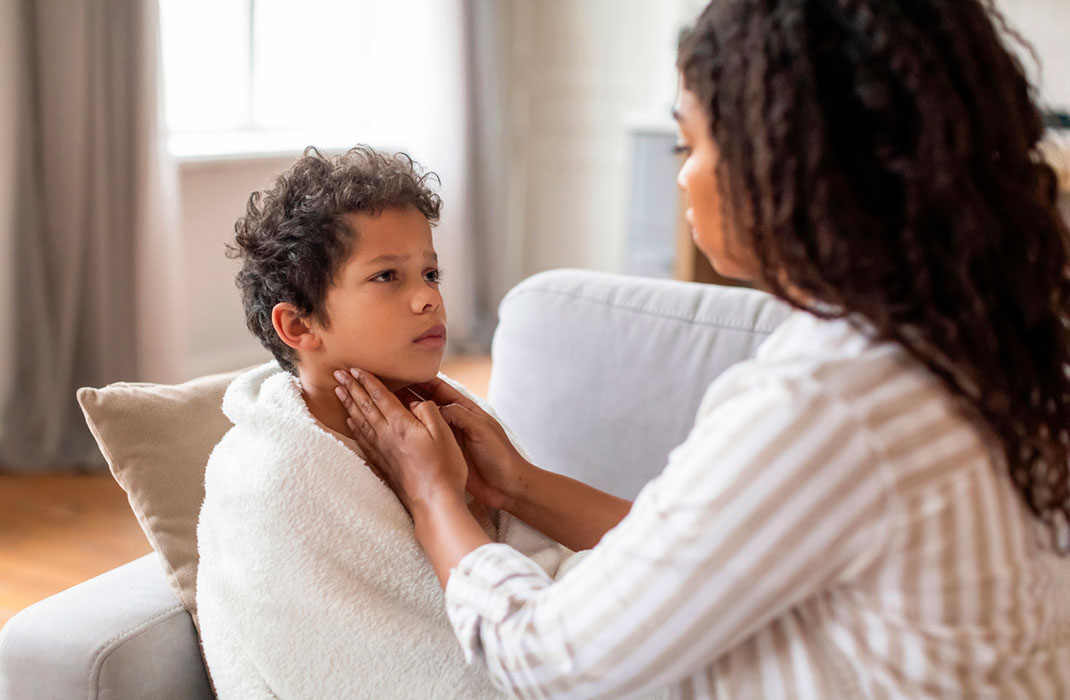 A mother feels her child’s neck for signs of strep throat. 