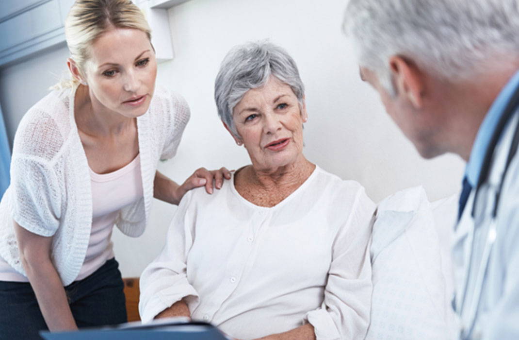 A patient and her adult daughter speak to a doctor