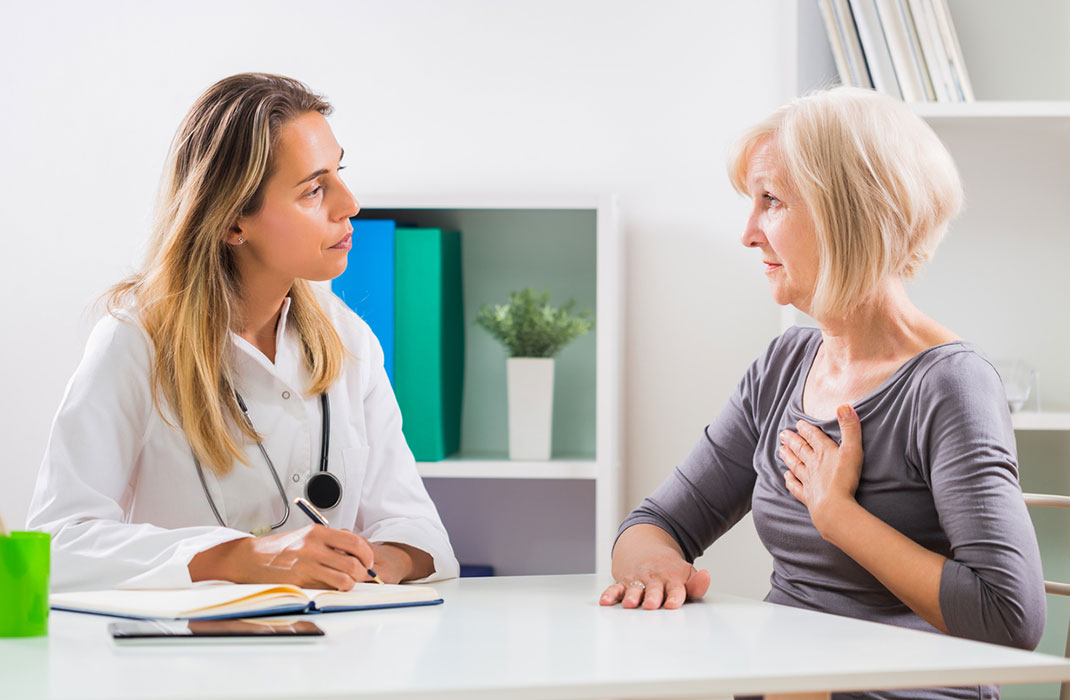 A patient talks to their doctor about chest pain in a medical office