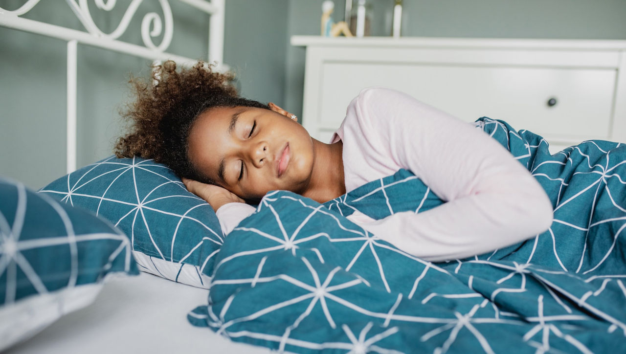 Young girl sleeping in bed.