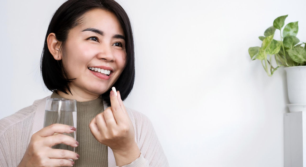 A woman takes medication for her high cholesterol treatments