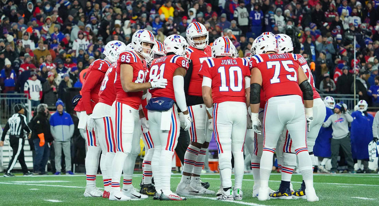 A group of football players huddle on the field