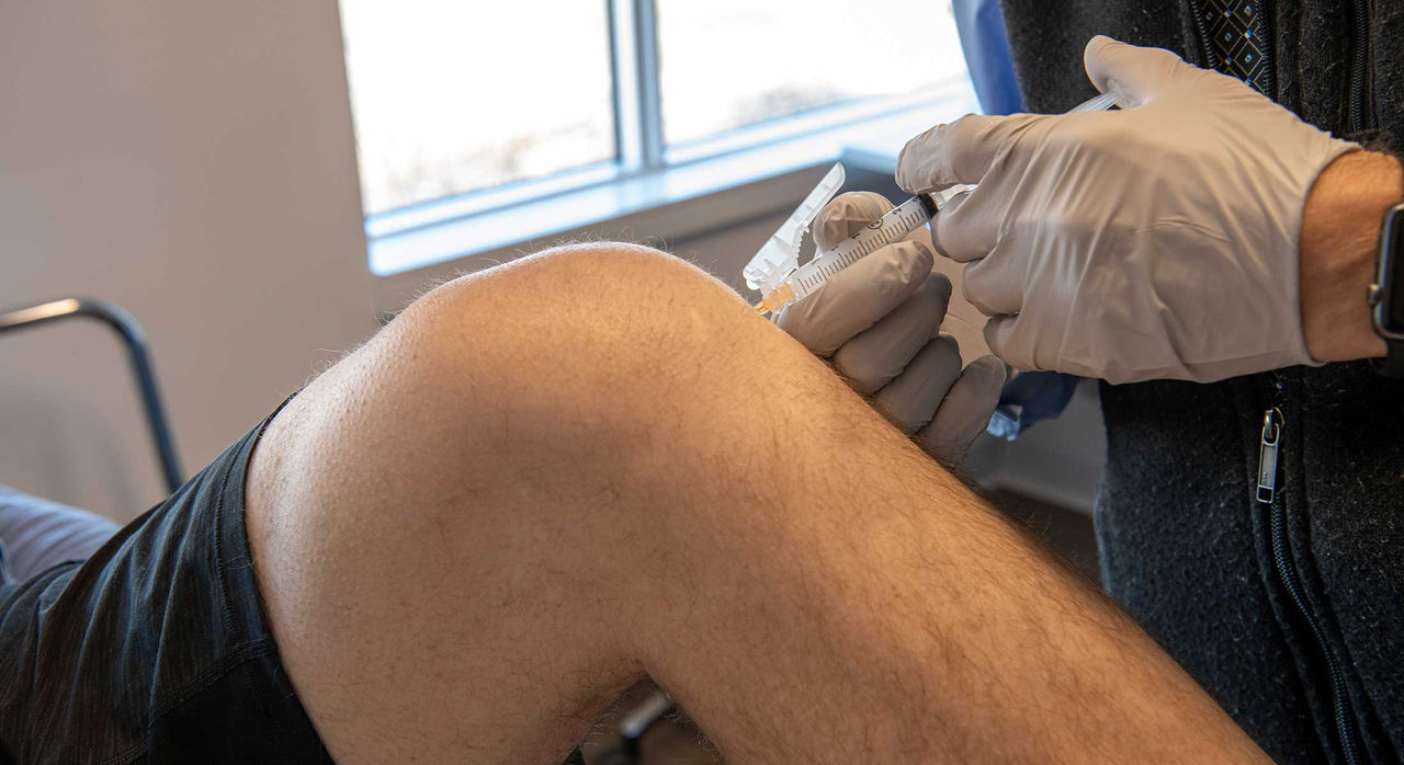 doctor treating patient with injections for knee pain