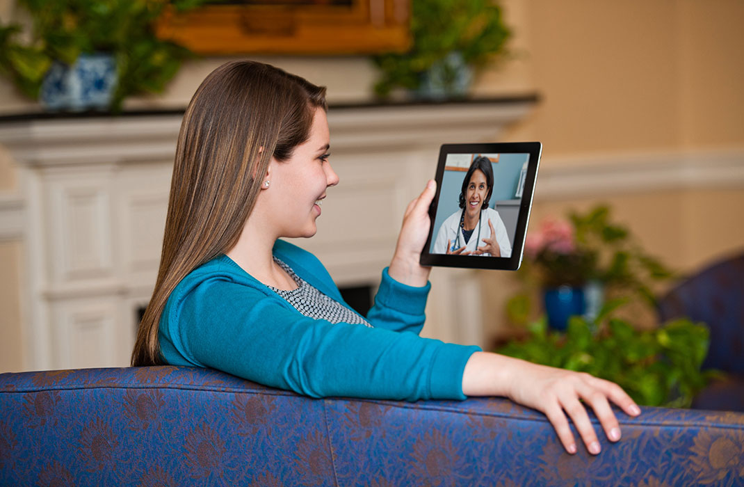 Person holding a tablet talking with a doctor 