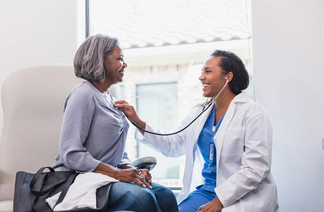A doctor listens to a patient’s heart rate.