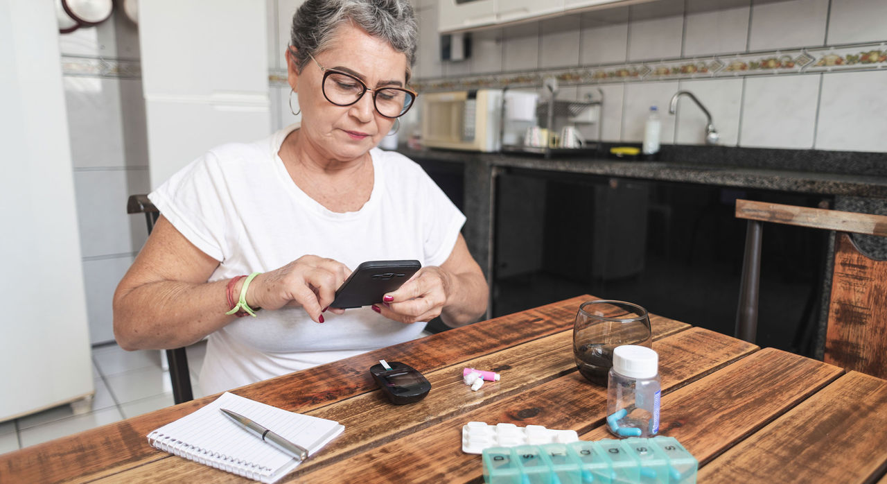 Woman with diabetes checking her blood sugar at home
