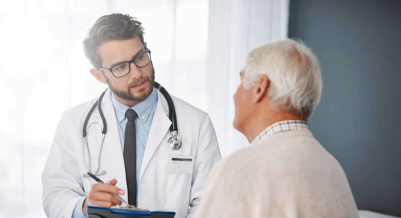 A physician consults with an older male patient.