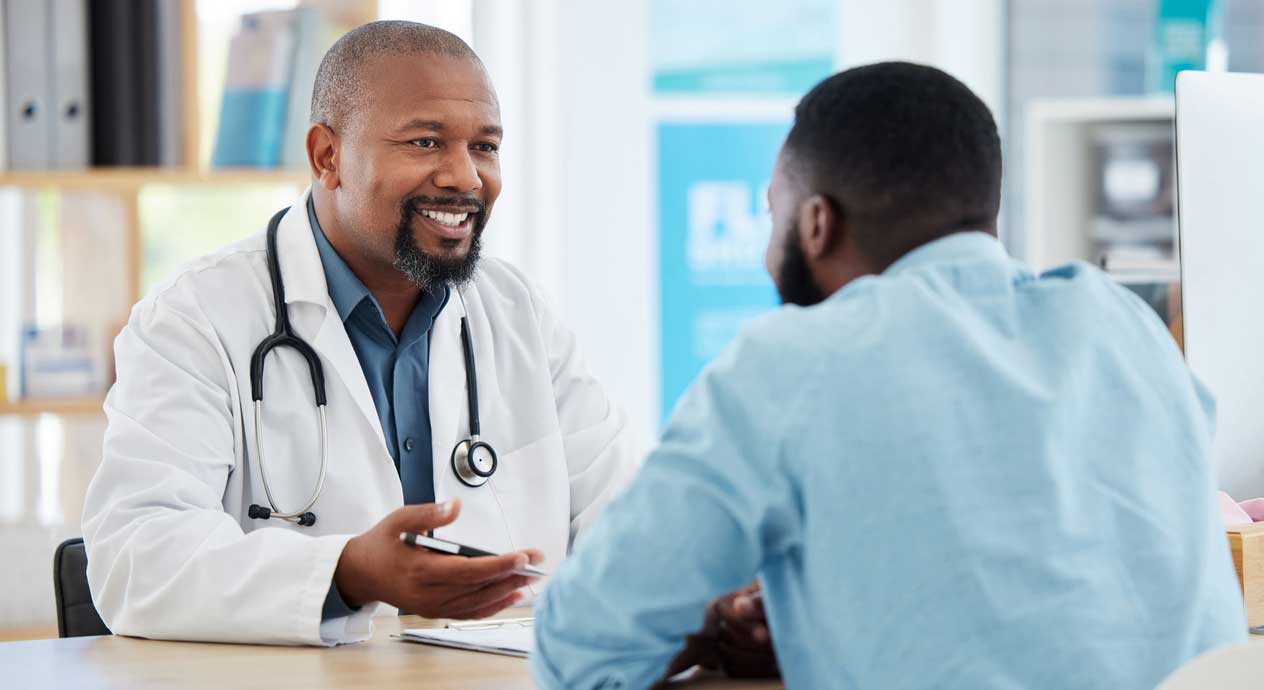 A young adult man meets with his doctor about colorectal cancer causes in young people.