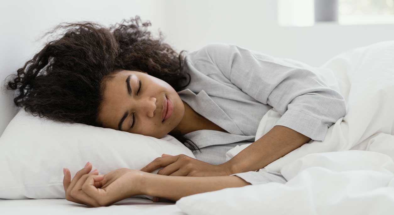 A contented-looking woman sleeping in bed.