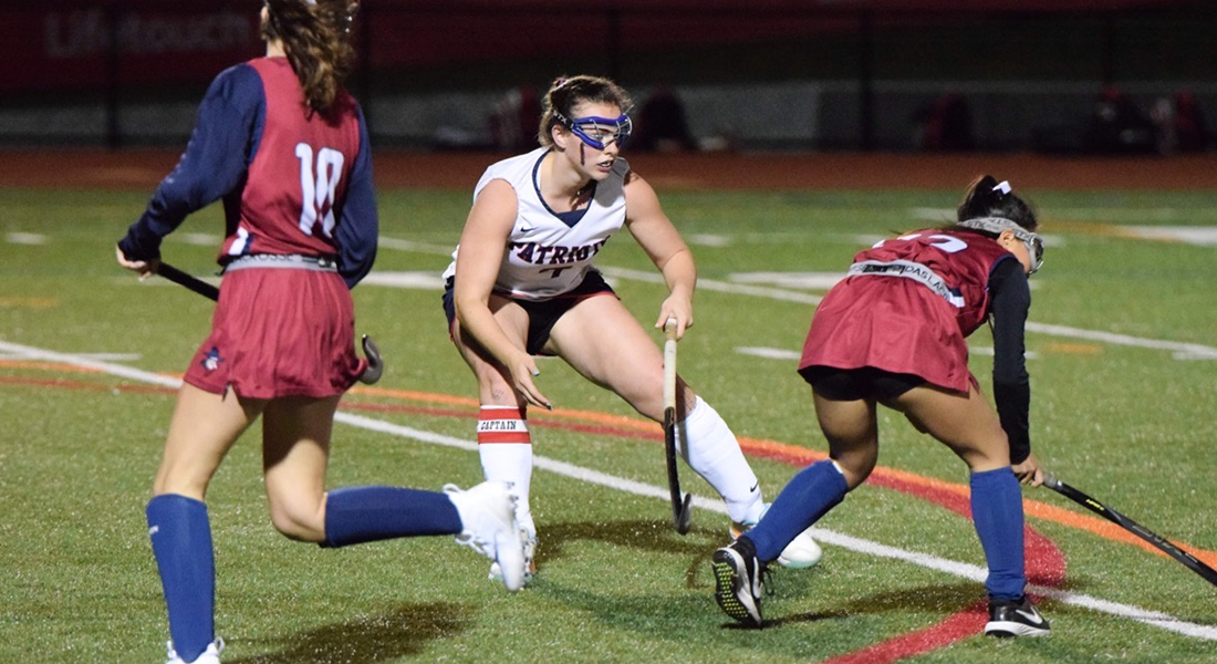 Lily playing field hockey with teammates