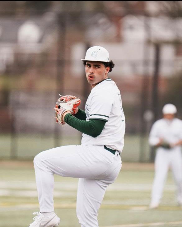 Angelo in baseball uniform, winding up to pitch.