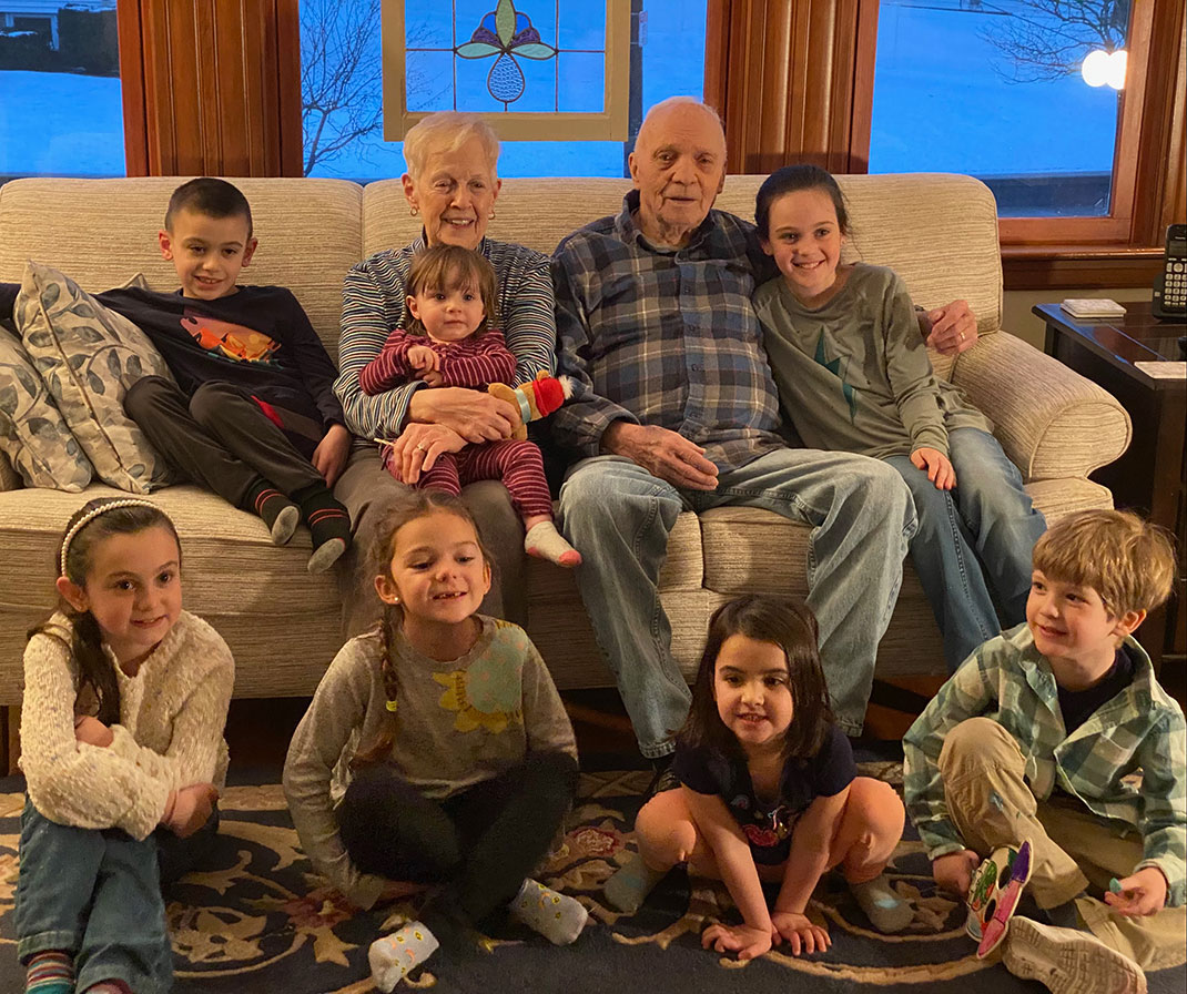 Bill and Mary Hanafin on their sofa with their seven youngest grandchildren and great-grandchildren, all under 12.