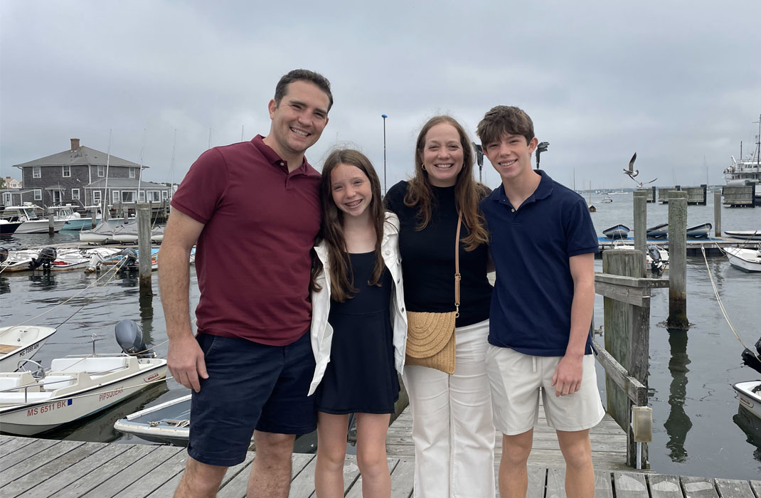 Chris Kobos standing with his family in summer 2024.