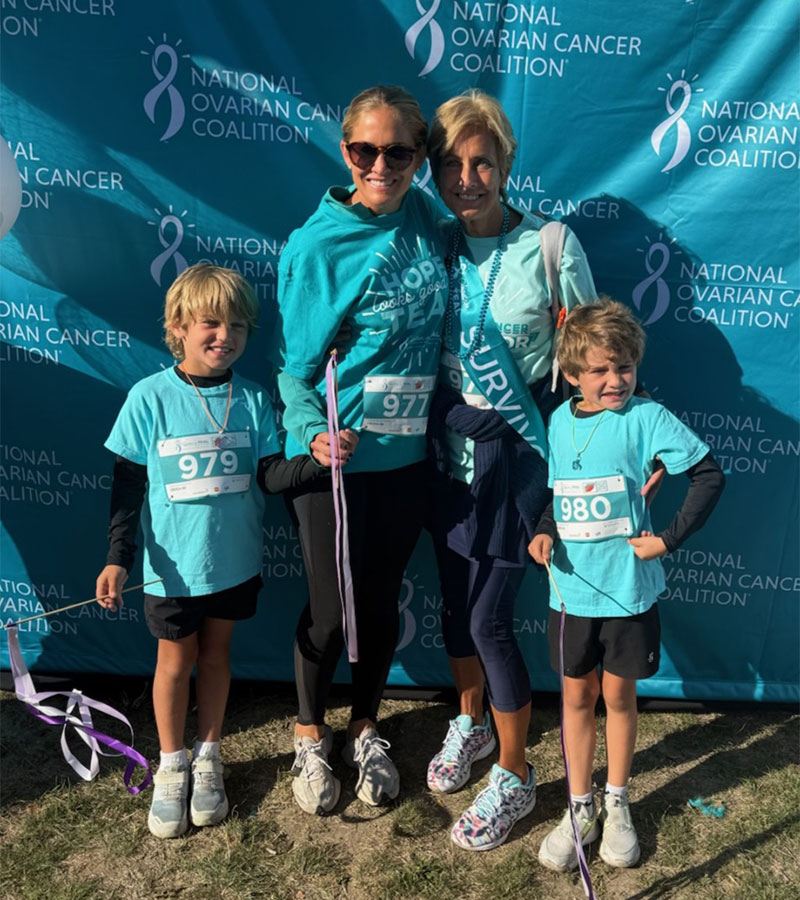 A group of individuals wearing teal shirts and ribbons participate in an outdoor event for the National Ovarian Cancer Coalition.