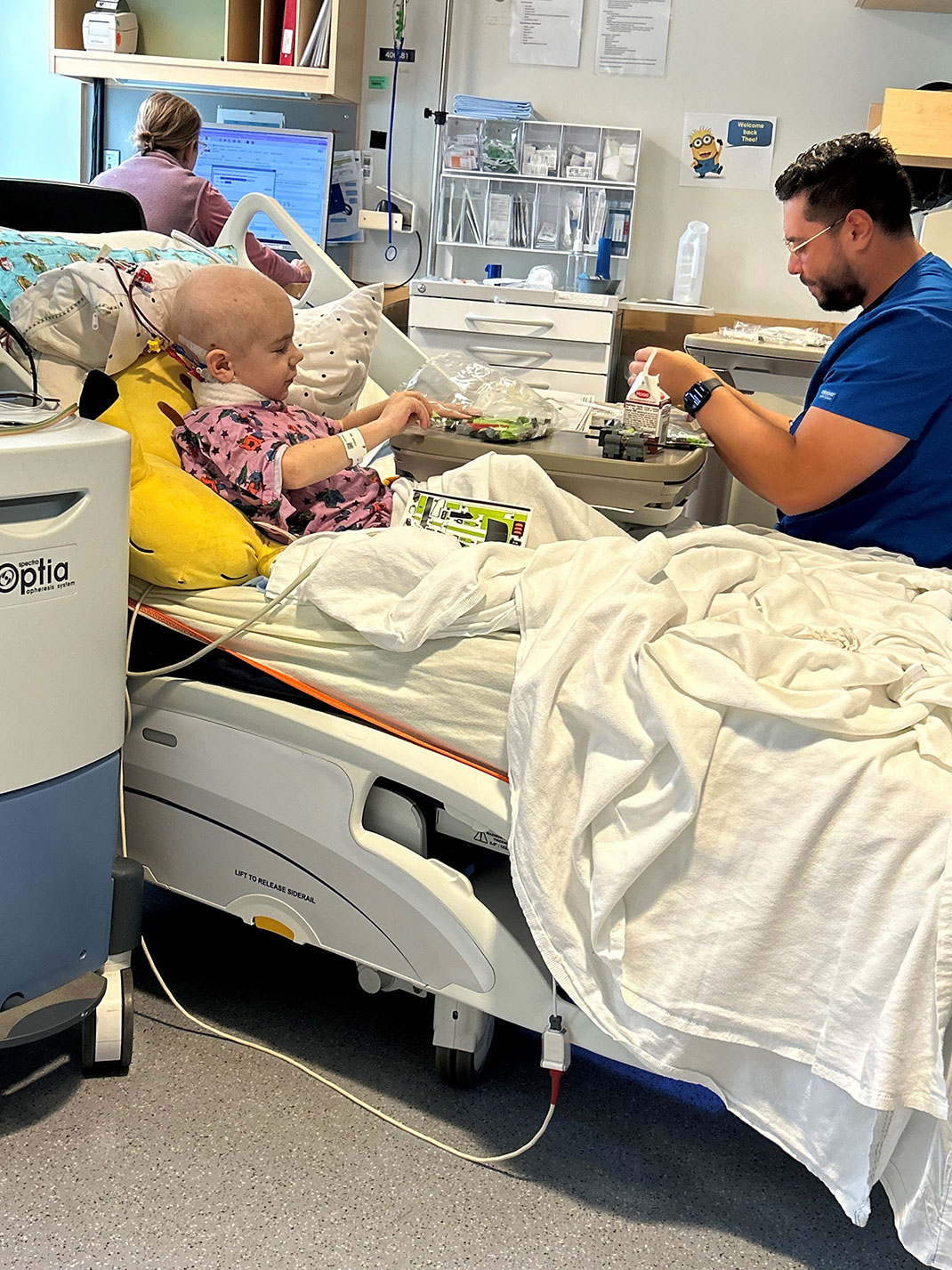 Theo building Legos with a nurse during his first stem cell collection in July 2023