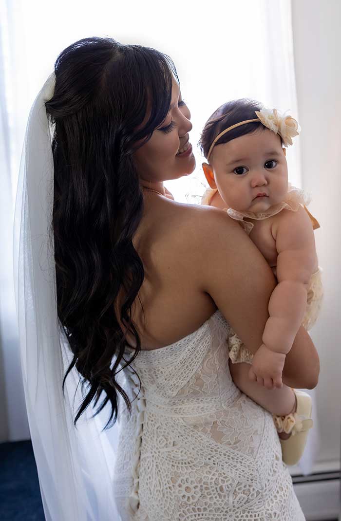 In her wedding dress, Katherine holds her baby girl, Amari.