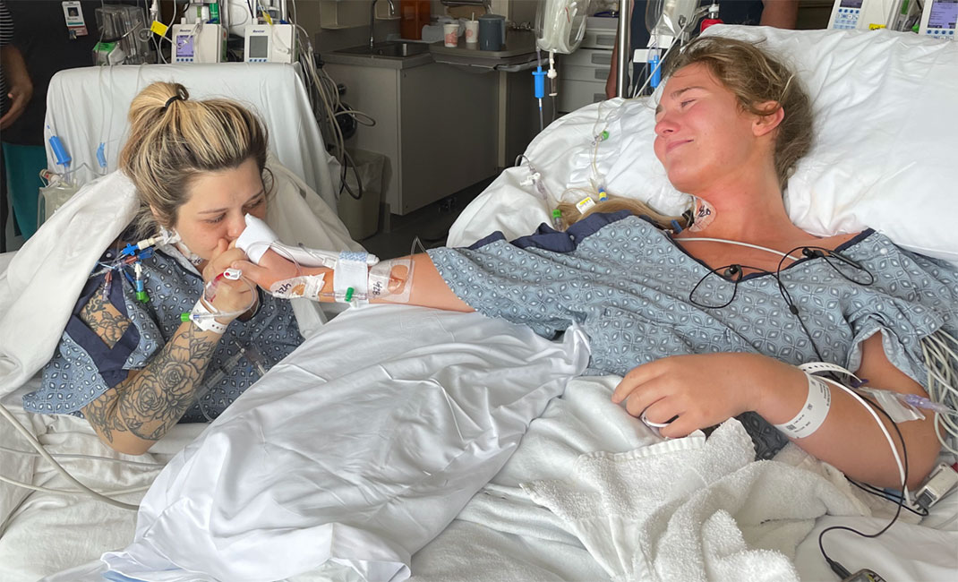 Brayden kisses Melissa's hand in the hospital after her donor surgery.