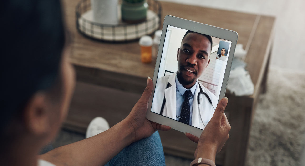 A patient in their home meets virtually with a provider.