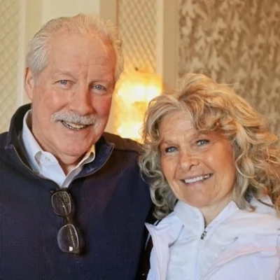 An older husband and wife couple smiling next to each other