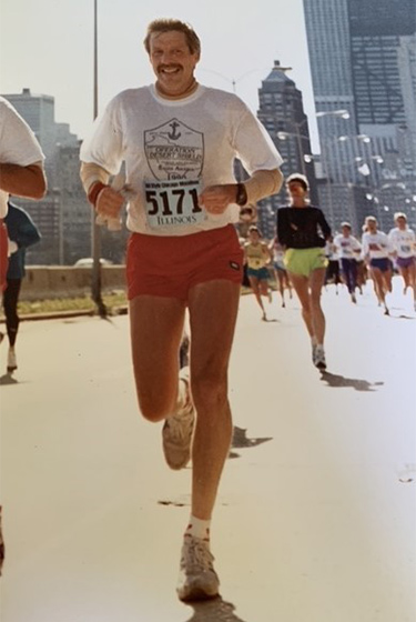 An older, vintage-looking image of a man running in the Chicago marathon