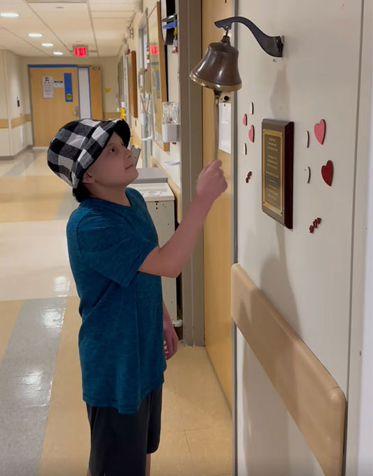 Remy rings the bell after completing ART treatment.