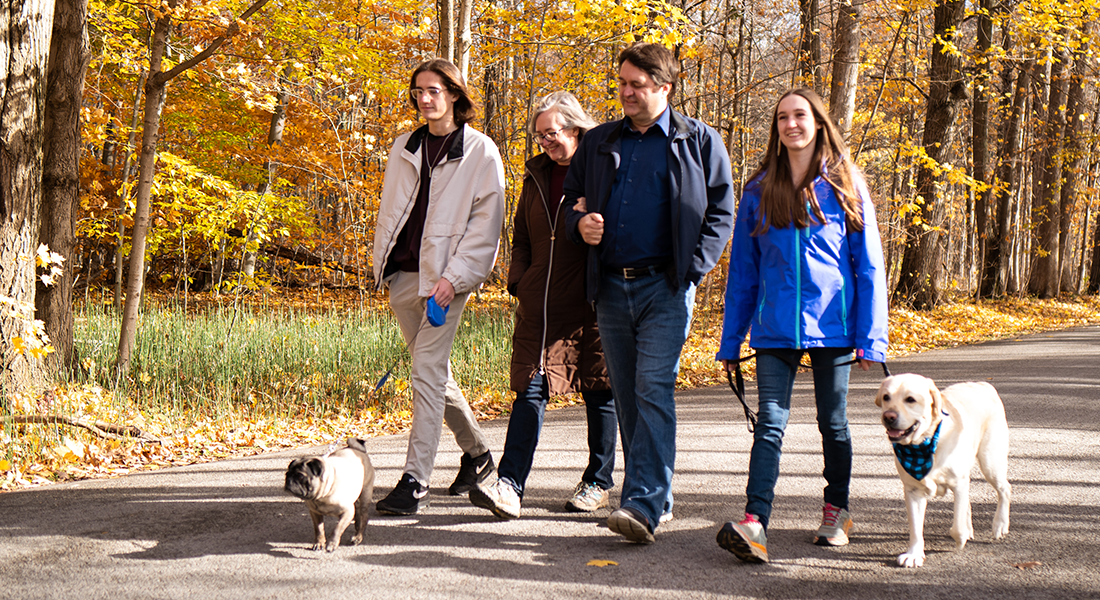Sydney walking in park on a fall day with her family and dogs 