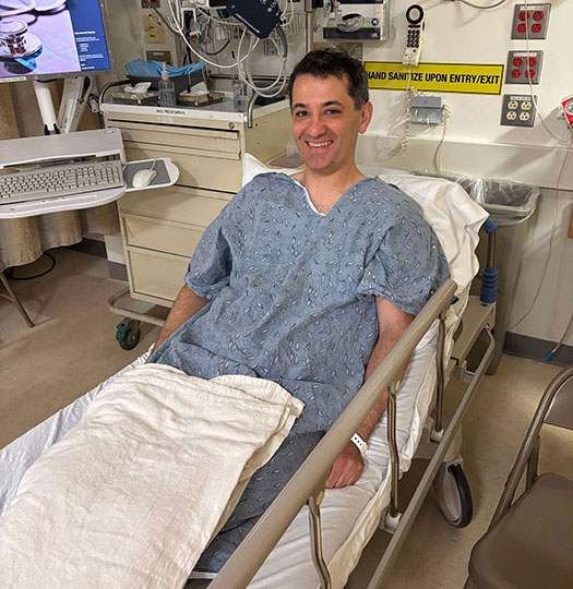 Photo of smiling man sitting up in hospital bed