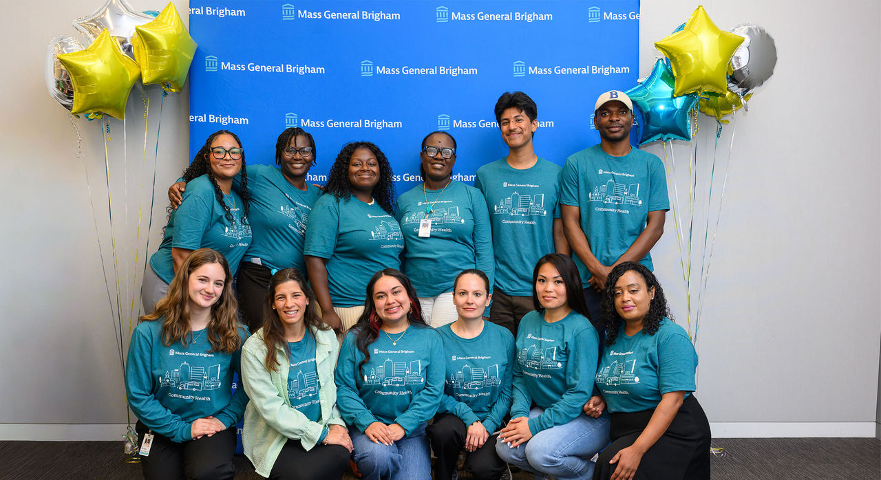 Community Health Improvement Corps members in front of a Mass General Brigham step-and-repeat and star-shaped balloons.